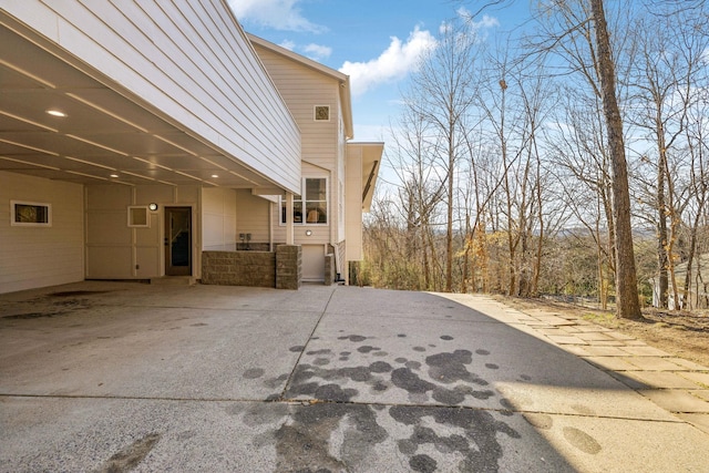 view of property exterior with stone siding and a carport