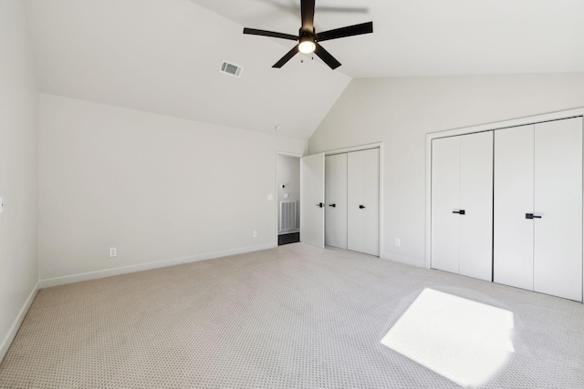 unfurnished bedroom with visible vents, light carpet, high vaulted ceiling, multiple closets, and a ceiling fan