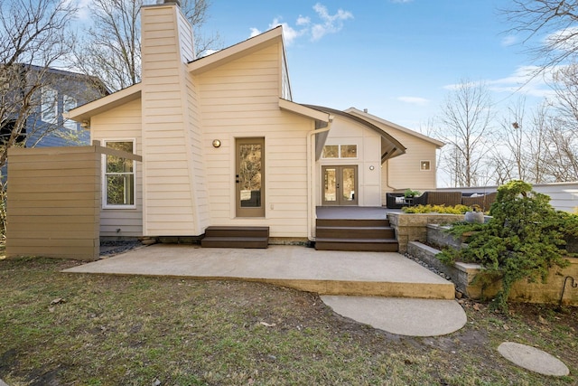 back of house with a patio area, french doors, and a chimney