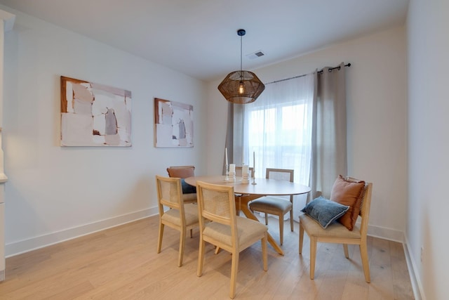 dining area featuring visible vents, baseboards, and light wood-type flooring