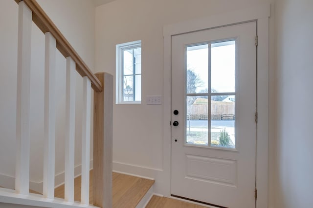 entryway featuring stairway, wood finished floors, and baseboards