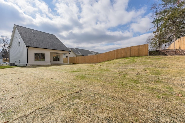 view of yard featuring central AC unit and fence