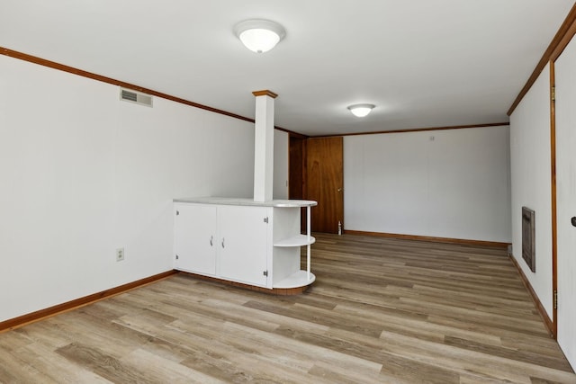 spare room with visible vents, light wood-type flooring, and crown molding