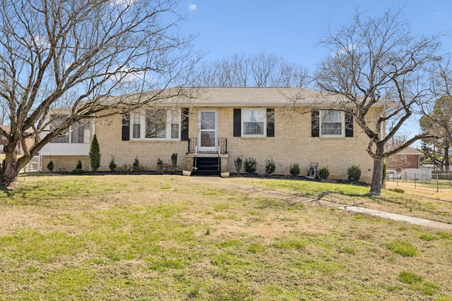 ranch-style house with brick siding, a front yard, and fence