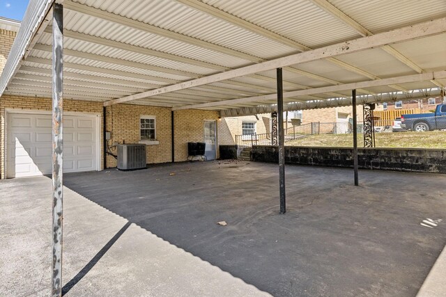 view of parking featuring a garage and fence