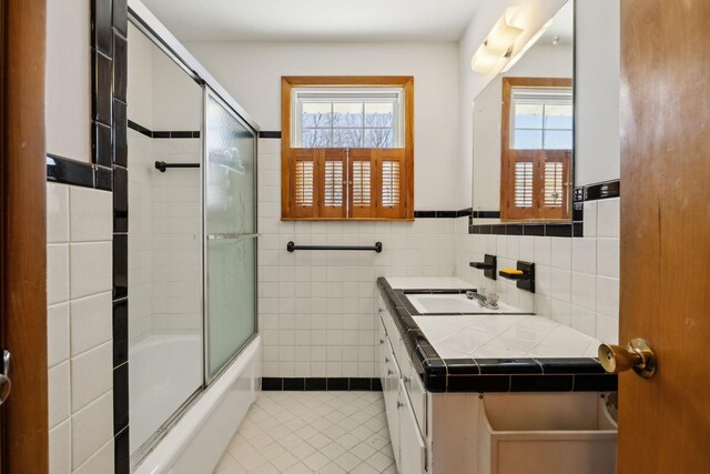 bathroom featuring tile patterned floors, a healthy amount of sunlight, tile walls, and vanity