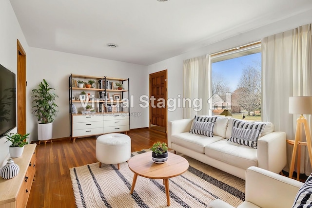 living room featuring visible vents, baseboards, and dark wood-style flooring