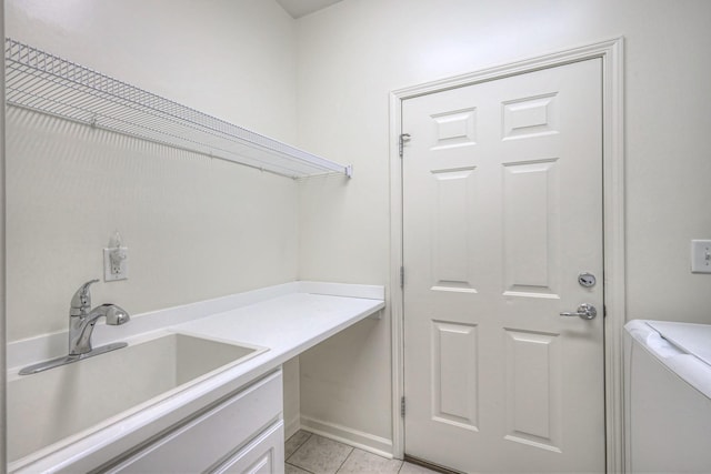 laundry area featuring washer and dryer, laundry area, light tile patterned flooring, and a sink