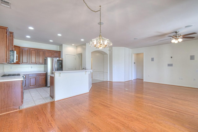 kitchen featuring visible vents, brown cabinets, light wood-style floors, appliances with stainless steel finishes, and light countertops