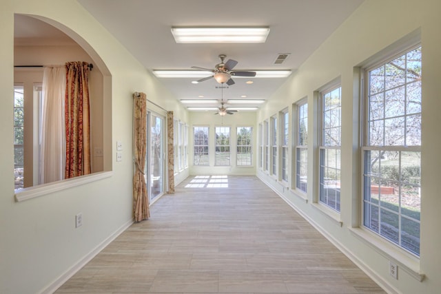 unfurnished sunroom featuring visible vents and ceiling fan