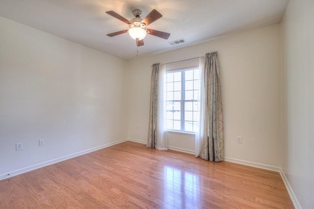 spare room featuring ceiling fan, baseboards, visible vents, and light wood-type flooring