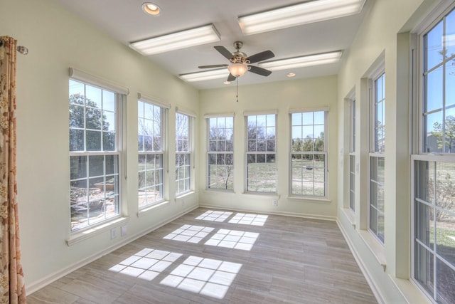 unfurnished sunroom featuring a ceiling fan and a healthy amount of sunlight