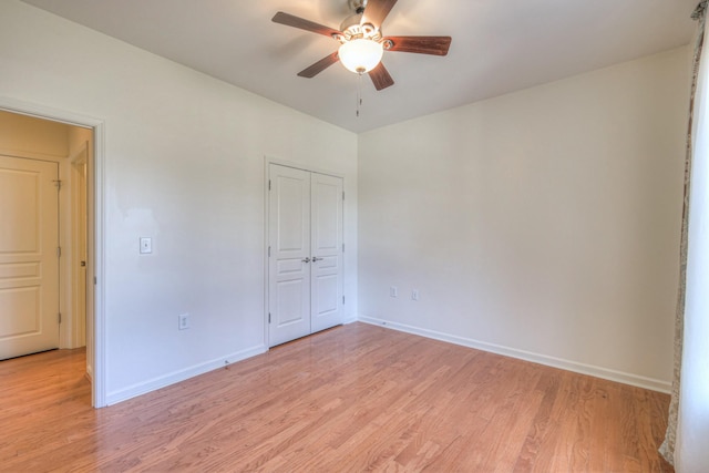 unfurnished bedroom with a closet, baseboards, and light wood-style floors