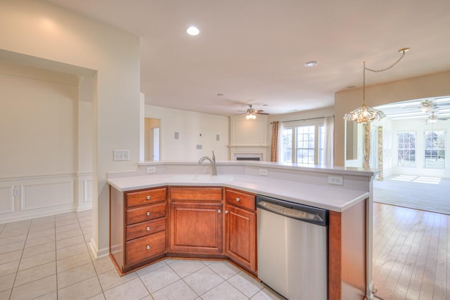 kitchen with dishwasher, light countertops, open floor plan, and a sink