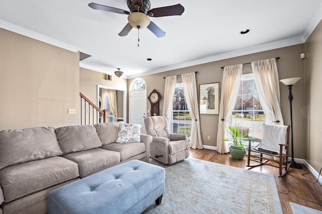 living area with ornamental molding, stairs, baseboards, and wood finished floors