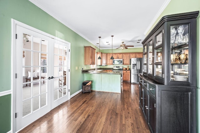 kitchen featuring dark wood-type flooring, a sink, appliances with stainless steel finishes, a peninsula, and crown molding