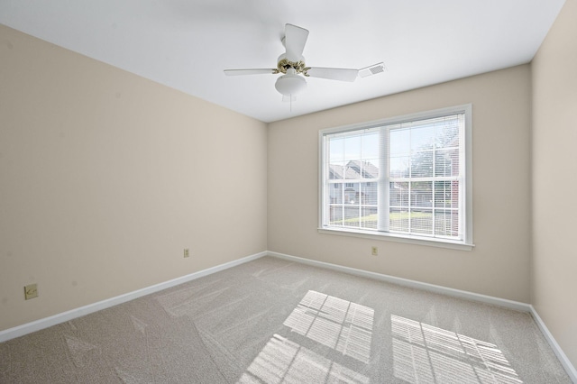 unfurnished room featuring ceiling fan, visible vents, baseboards, and light carpet