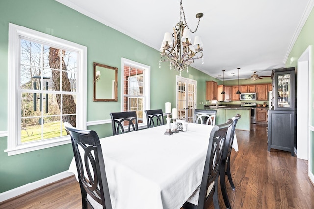 dining space featuring baseboards, ceiling fan with notable chandelier, dark wood finished floors, and ornamental molding