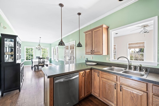 kitchen with dark countertops, a sink, plenty of natural light, and stainless steel dishwasher