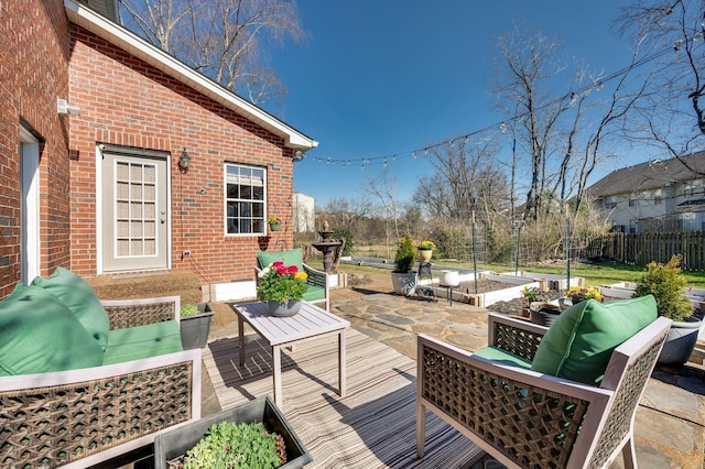 deck with an outdoor living space, a vegetable garden, fence, and a patio