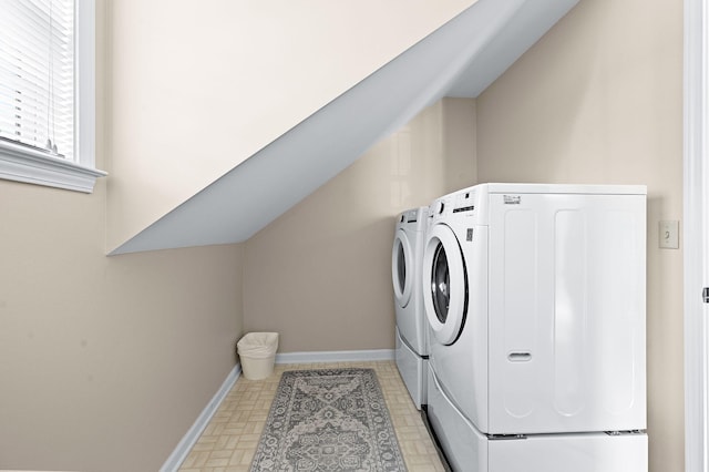 laundry area with laundry area, separate washer and dryer, and baseboards