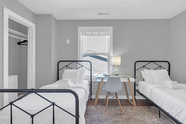 bedroom with visible vents, baseboards, and wood finished floors