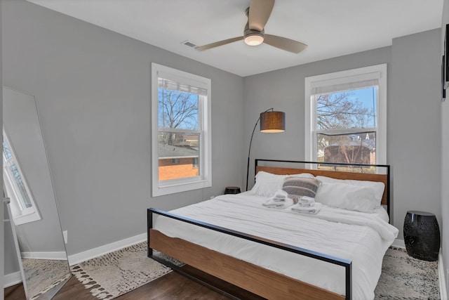 bedroom featuring visible vents, ceiling fan, baseboards, and dark wood-style flooring