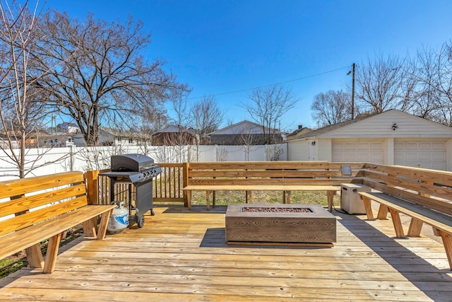 wooden deck featuring an outbuilding, grilling area, a garage, and a fenced backyard