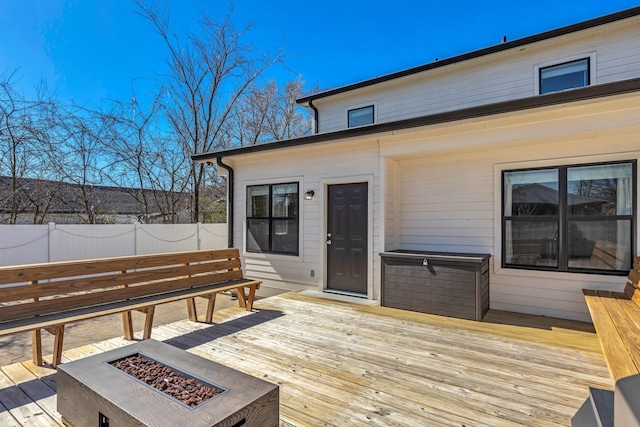 wooden terrace featuring an outdoor fire pit and fence