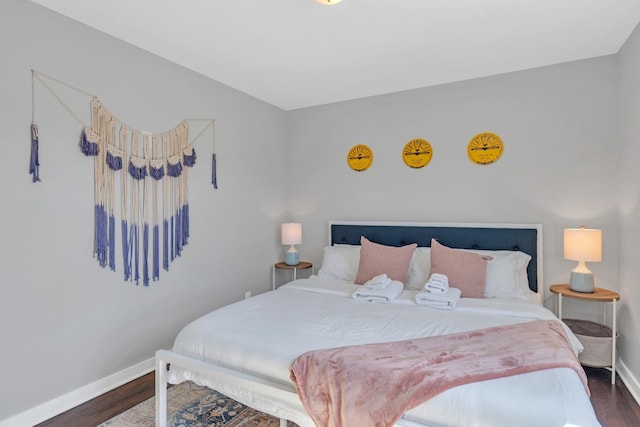 bedroom featuring baseboards and dark wood-style flooring