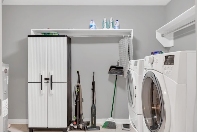 laundry room with tile patterned flooring, baseboards, water heater, cabinet space, and independent washer and dryer