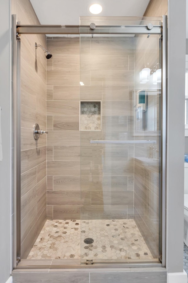 full bathroom with a shower stall and toilet