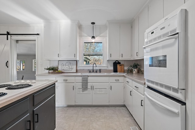 kitchen featuring a sink, plenty of natural light, white cabinets, and light countertops