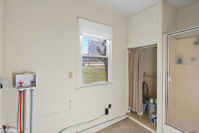 laundry area featuring washer hookup, crown molding, and light tile patterned flooring