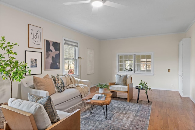 living room with baseboards, a ceiling fan, wood finished floors, and crown molding