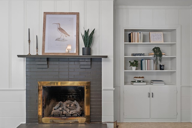 details with a brick fireplace and built in shelves