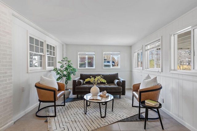 living room with tile patterned floors and a decorative wall