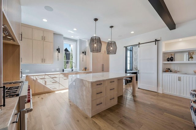 kitchen featuring high end stove, light brown cabinets, light wood-style floors, and a barn door