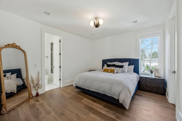 bedroom with wood finished floors and connected bathroom