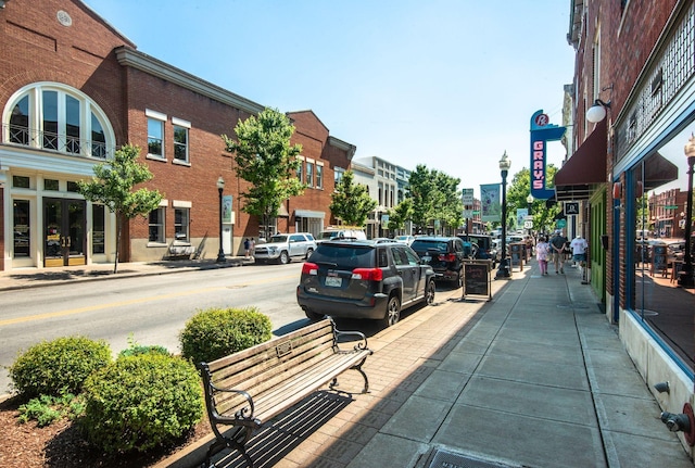 view of street featuring curbs, sidewalks, and street lighting