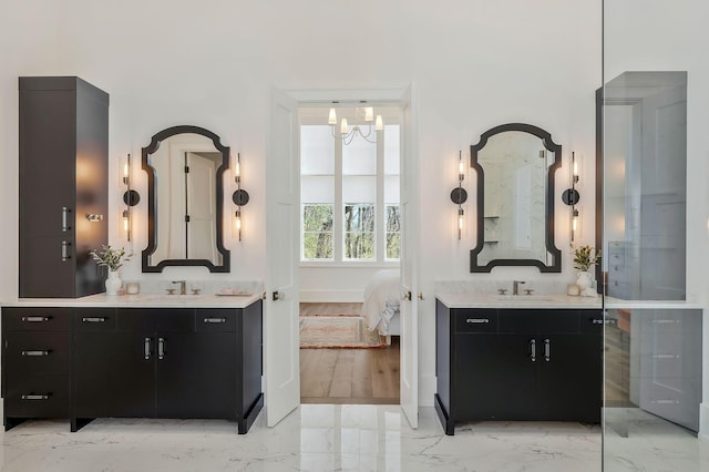 full bathroom featuring a sink, two vanities, marble finish floor, and ensuite bathroom