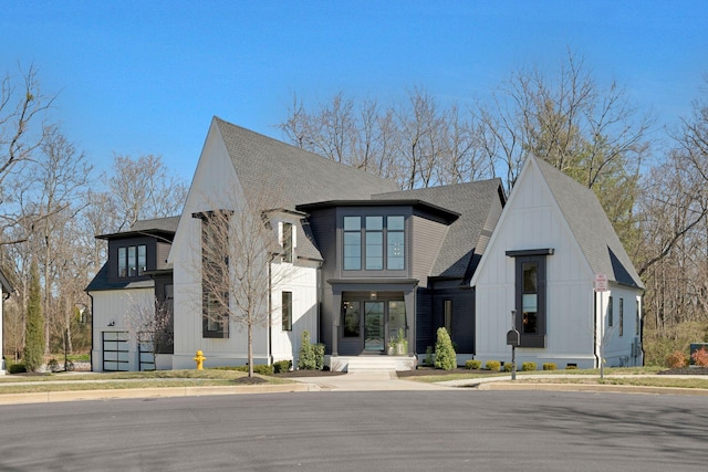 modern inspired farmhouse featuring board and batten siding and a shingled roof