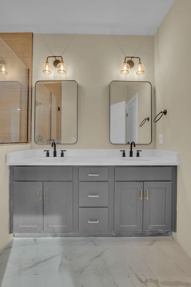 full bath with a sink, marble finish floor, and double vanity