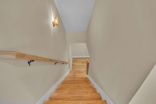 staircase with baseboards and wood finished floors