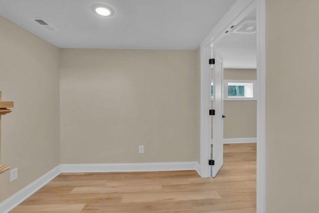 unfurnished room featuring visible vents, baseboards, and light wood-style floors