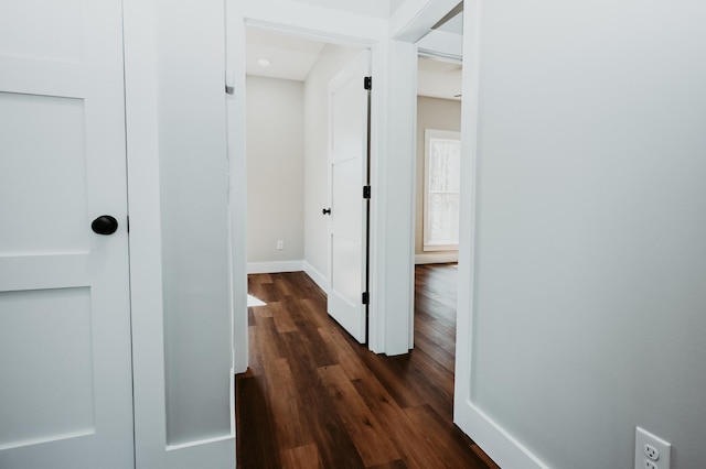 hallway with dark wood-style floors and baseboards