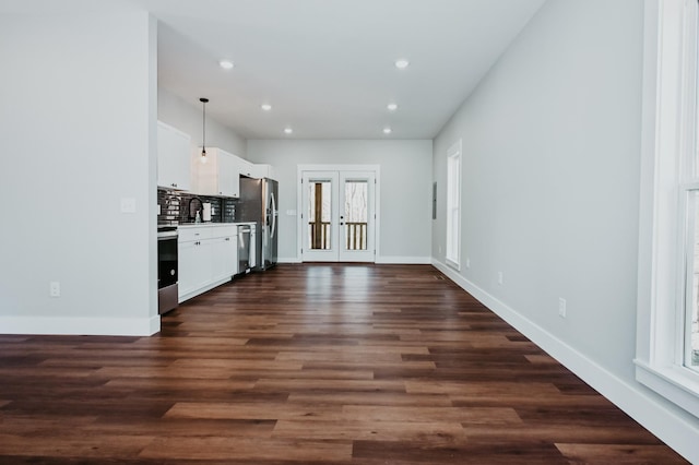 kitchen with tasteful backsplash, recessed lighting, appliances with stainless steel finishes, french doors, and white cabinets