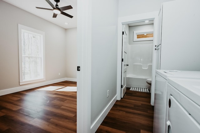 washroom with washing machine and clothes dryer, a healthy amount of sunlight, and dark wood-style flooring