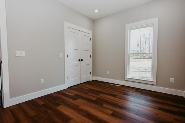 unfurnished bedroom featuring dark wood finished floors, recessed lighting, visible vents, and baseboards