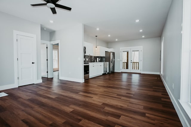 unfurnished living room with recessed lighting, french doors, baseboards, and dark wood-style flooring